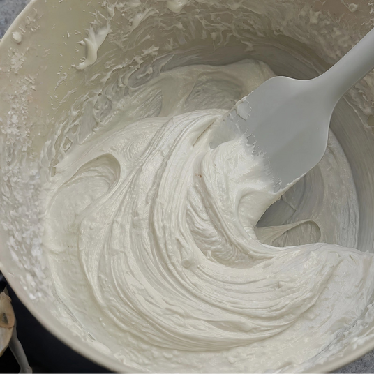 Botanical haircare formula being hand-mixed in a bowl.